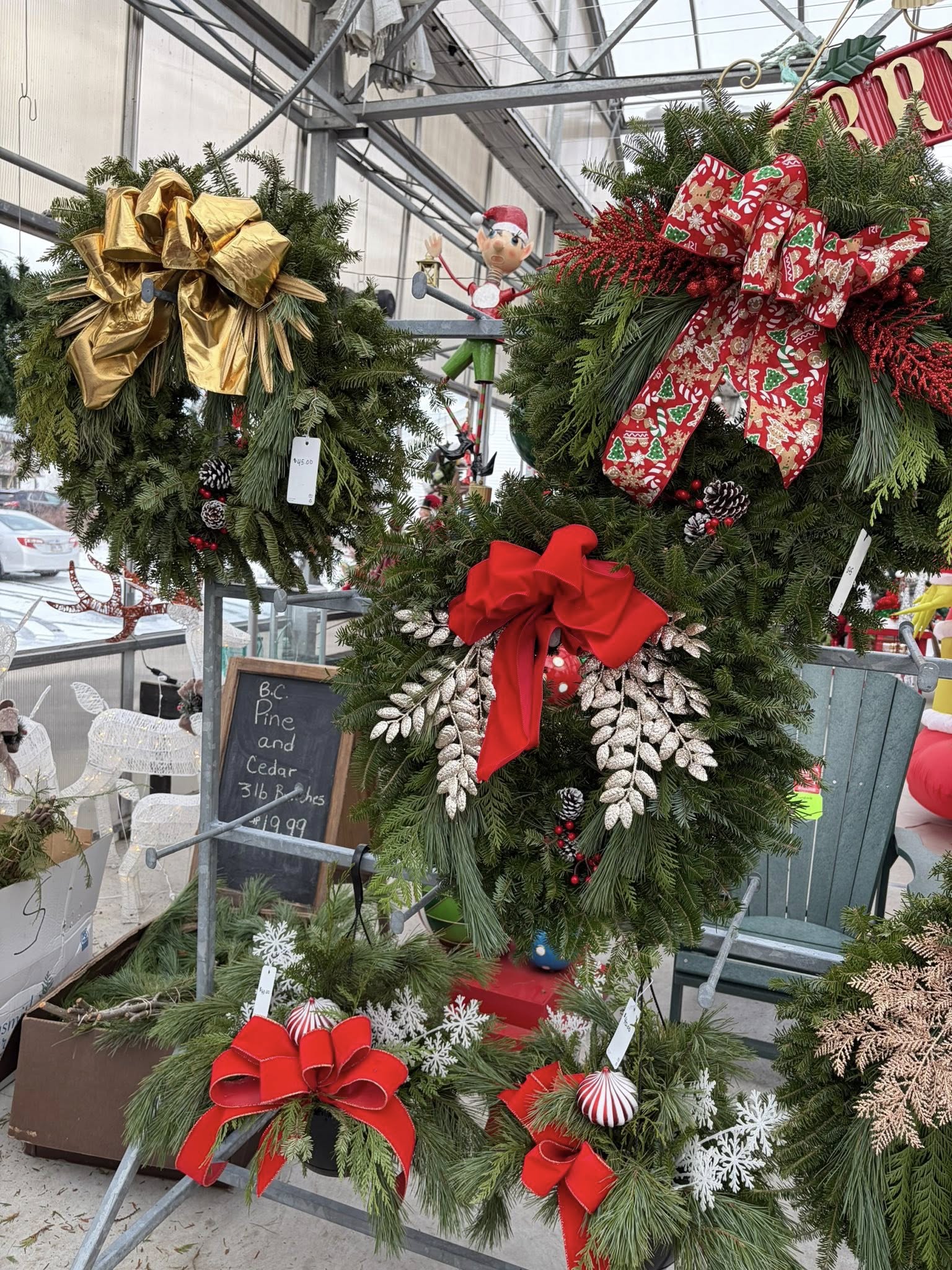 Decorative wreaths with large bows on display in a store setting.